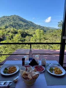 a table with plates of food and a view of a mountain at Minca Seasons Birds in Minca