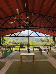 a group of tables and benches under a roof at Minca Seasons Birds in Minca