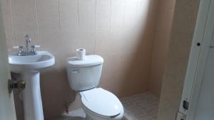 a bathroom with a toilet and a sink at Spacious house near the beach in Mazatlán