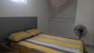 a small bedroom with a bed with a fan at Spacious house near the beach in Mazatlán