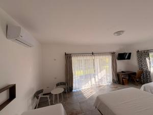 a bedroom with two beds and a window and a table at Dos Mundos Pacific Resort in Monterrico
