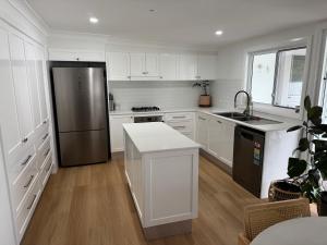 a kitchen with white cabinets and a stainless steel refrigerator at SAND Haus in North Haven