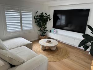 a living room with a couch and a tv at SAND Haus in North Haven