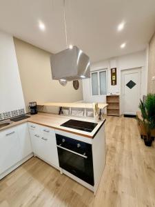 a kitchen with white cabinets and a stove top oven at La Maison du Souvenir in Beaucourt-sur-lʼAncre +17 photos