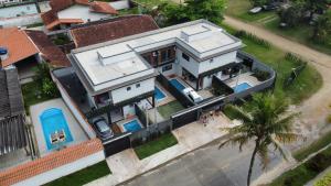 an overhead view of a house with a palm tree at Refúgio 4 Praia Indaiá Bertioga 150 mts da praia in Bertioga