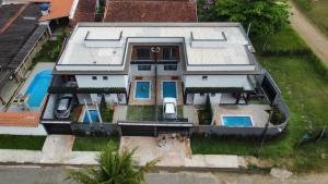 an aerial view of a house with a swimming pool at Refúgio 4 Praia Indaiá Bertioga 150 mts da praia in Bertioga
