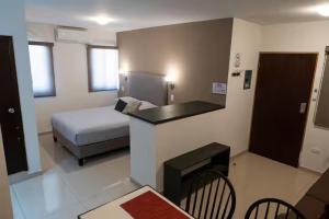 a hotel room with a bed and a desk and a room at Casa Rosales in Los Mochis