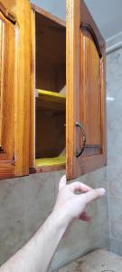 a hand is pointing at a cabinet in a kitchen at A ROOM in mandara in Alexandria