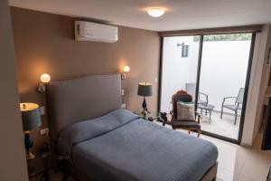 a bedroom with a blue bed and a balcony at Casa Rosales in Los Mochis