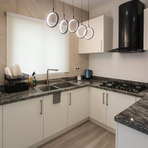 a kitchen with white cabinets and a sink at Gift cozy 1 bedroom in Lekki