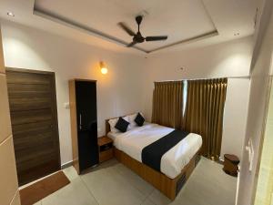 a bedroom with a bed and a ceiling fan at Nellarachal Homestay in Ambalavayal