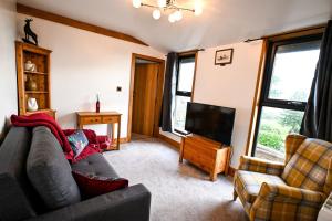 a living room with a couch and a flat screen tv at Piglets Place in Hythe