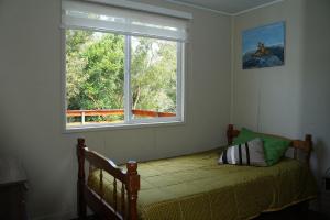 a bedroom with a bed and a large window at Casa completa en Carretera Austral KM 23 con Fibra Óptica in Puerto Montt