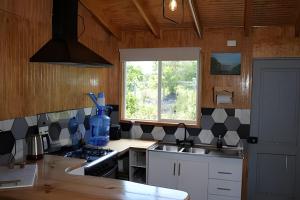 a kitchen with a sink and a stove and a window at Casa completa en Carretera Austral KM 23 con Fibra Óptica in Puerto Montt +20 photos