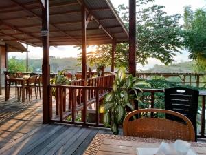 a patio with tables and chairs on a wooden deck at Feby's Homestay in Ekas