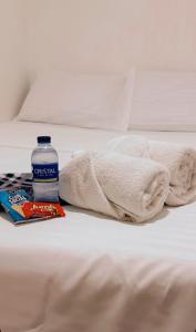 a bottle of water and a blanket on a bed at hotel chanel in Itagüí