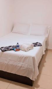 a white bed with a bottle of water on it at hotel chanel in Itagüí