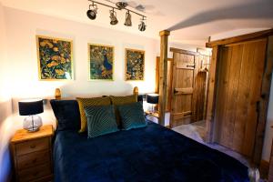 a bedroom with a bed with blue sheets and pillows at Eeyore's Place in Hythe