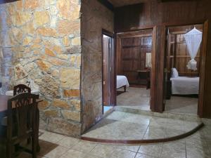 ein Zimmer mit einer Steinwand und ein Schlafzimmer in der Unterkunft Hotel Nueva Alianza in Frontera Corozal