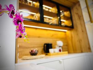 a vase with purple flowers on top of a counter at SOL LUX Tuzla in Tuzla +49 photos