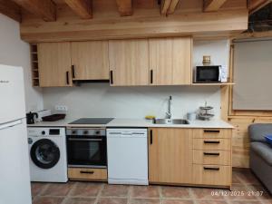 a kitchen with a stove and a sink and a microwave at Cal RAFELÓ in Queralbs