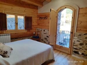 a bedroom with a bed and a large window at Cal RAFELÓ in Queralbs