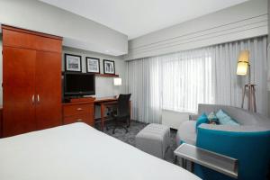 a hotel room with a bed and a couch and a desk at Courtyard by Marriott Jacksonville I-295/East Beltway in Jacksonville
