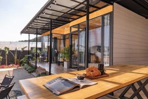 a house with a wooden table with a book on it at Bin Home in Ấp Kim Thạch