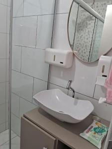 a bathroom with a white sink and a mirror at Pousadinha só in Foz do Iguaçu