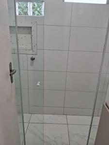 a shower with a glass door in a bathroom at Pousadinha só in Foz do Iguaçu