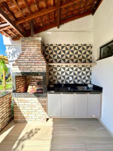 an outdoor kitchen with a brick wall and a fireplace at Casa Amaré Barreirinhas in Barreirinhas