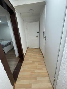 a hallway with a white door and a wooden floor at Haus Zum Bacchus Privates Unterkunft nahe Bahnhof Römisches Theater, Mainz in Mainz