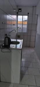 a kitchen with a counter with a sink and a window at Pousada familiar 05 in Rio do Sul