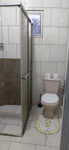 a bathroom with a toilet and a shower with a window at Pousada familiar 05 in Rio do Sul