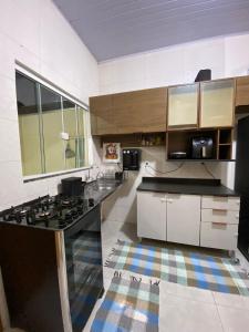 a large kitchen with a stove and a sink at Apto Aconchegante Próximo ao Centro! in Sinop +8 photos