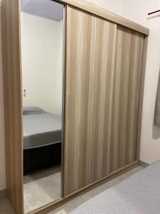a sliding glass door in a bedroom with a bed at Apto Aconchegante Próximo ao Centro! in Sinop
