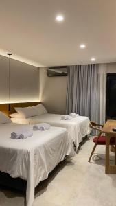 ein Hotelzimmer mit zwei Betten und einem Tisch in der Unterkunft Waves & Ko in San Andrés