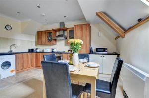 a kitchen with a wooden table and chairs and a kitchen with a sink at 2 Bed in Lynton oc-chap in Lynmouth