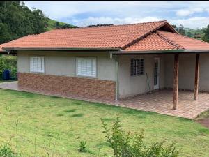 a small brick house with a red roof at Sítio Canario da Terra in Gonçalves