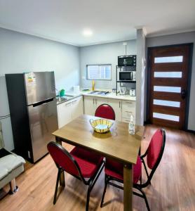a kitchen with a wooden table and red chairs at Arriendo en Valdivia cabañas in Valdivia