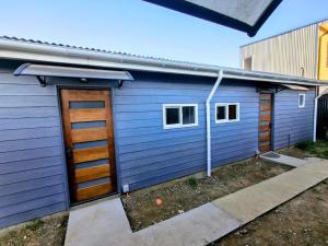 a blue garage with a door and ashed at Arriendo en Valdivia cabañas in Valdivia
