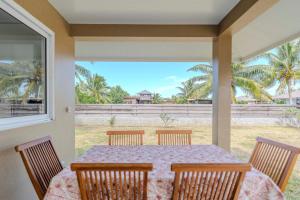 a dining room with a table and chairs on a porch at Moorea Maatea Tahatai Lodge in Moorea