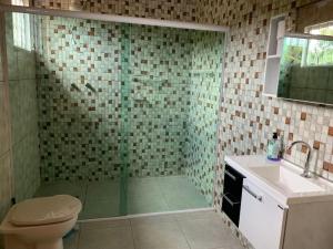 a bathroom with a shower with a toilet and a sink at Sítio Canario da Terra in Gonçalves +13 photos
