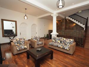 a living room with couches and a coffee table at Samindra Villa in Kandy
