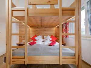a wooden bunk bed with red pillows in a room at BergbiberLODGE L in Piesendorf