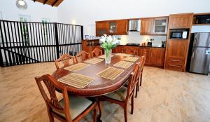 a dining room table with chairs and a kitchen at Samindra Villa in Kandy