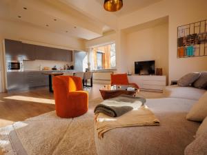 a living room with a couch and a kitchen at LOFT-54 -Exclusive Apartment with Terrace in Zwevegem