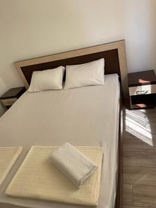 a bed with a wooden headboard with a towel on it at Lupo in Budva