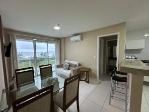 a kitchen and a living room with a glass table at Mandai Apart - Beira Mar in Cabo Frio