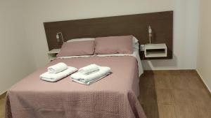 a bedroom with a bed with two towels on it at El Rincon del Descanso in General Alvear